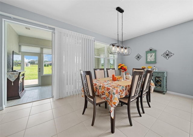 tiled dining space with a chandelier