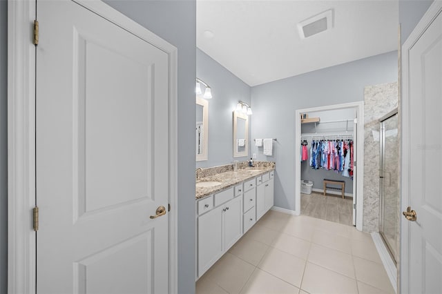 bathroom with tile patterned floors, vanity, and an enclosed shower