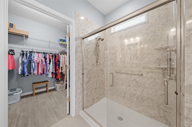 bathroom featuring a shower with door and hardwood / wood-style floors