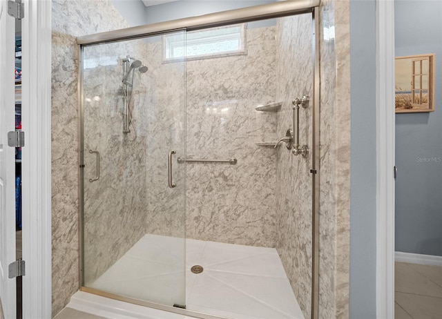 bathroom with a shower with door and tile patterned flooring