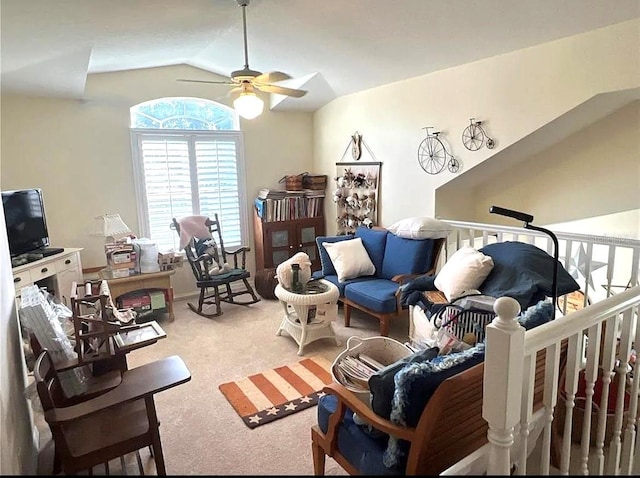 living area featuring lofted ceiling, a ceiling fan, and light colored carpet