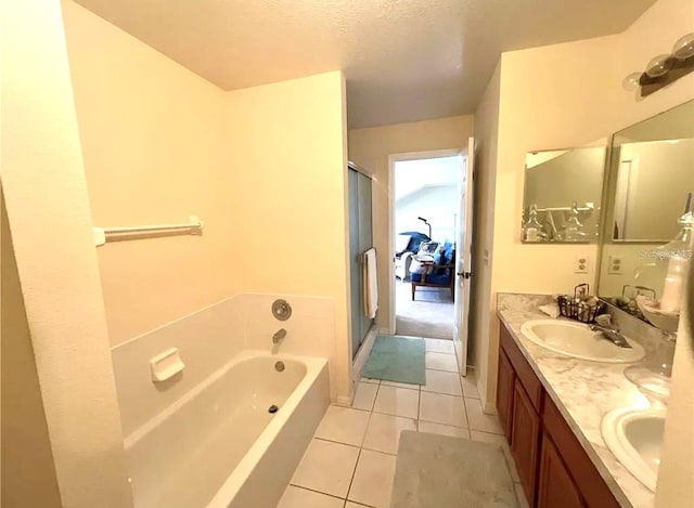 full bathroom with double vanity, a sink, a shower stall, tile patterned flooring, and a bath