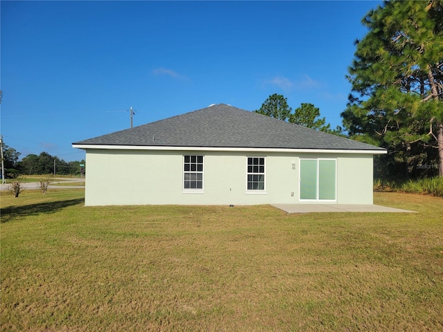 rear view of property with a patio and a lawn