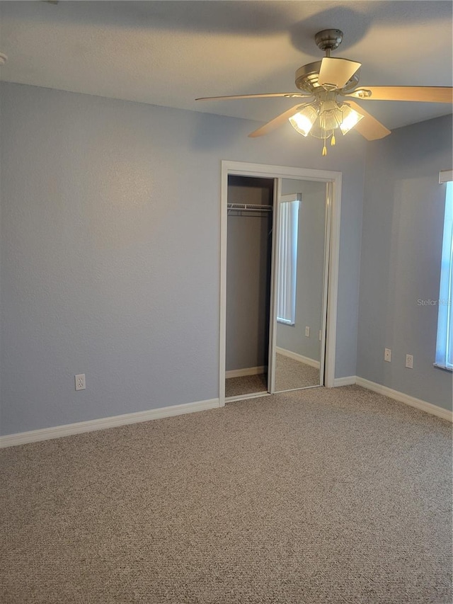 unfurnished bedroom with a closet, ceiling fan, and carpet flooring