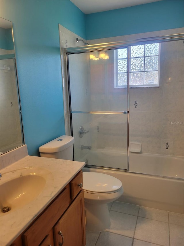 full bathroom with toilet, enclosed tub / shower combo, vanity, and tile patterned flooring