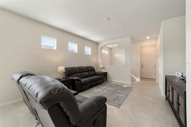 living room with a textured ceiling and light tile patterned floors