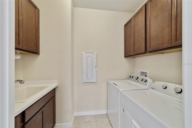 laundry room with light tile patterned floors, independent washer and dryer, sink, cabinets, and a textured ceiling