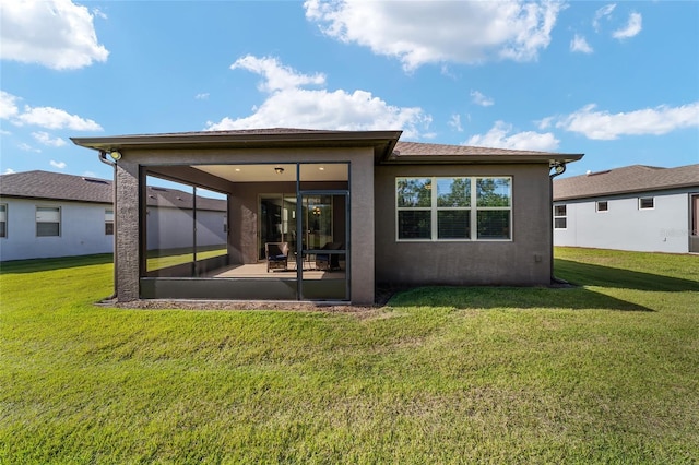 rear view of property featuring a lawn and a sunroom