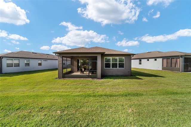 rear view of house featuring a lawn and a sunroom