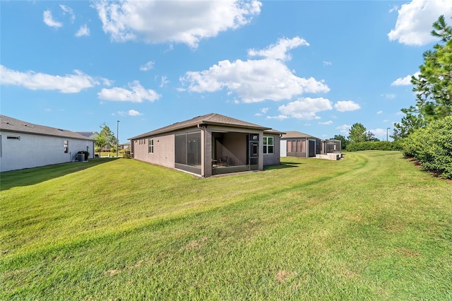 back of house featuring a yard and a sunroom