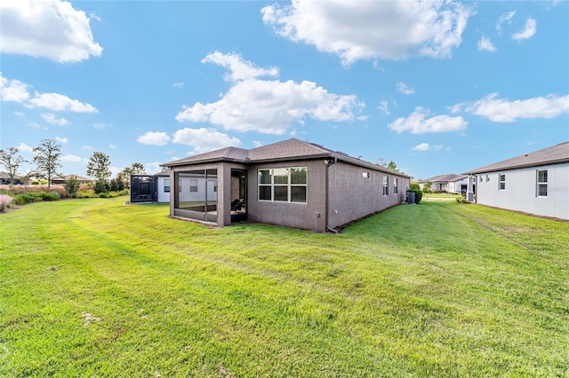 rear view of property featuring a lawn and a sunroom