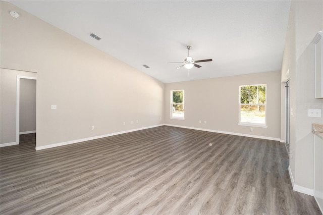 unfurnished living room with ceiling fan, a healthy amount of sunlight, lofted ceiling, and dark hardwood / wood-style flooring