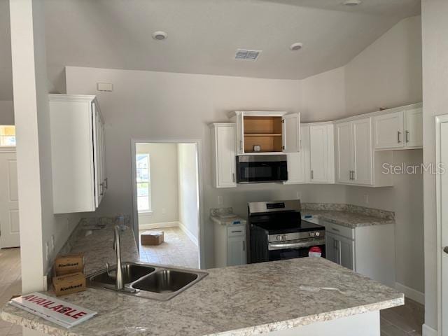 kitchen with sink, stainless steel appliances, lofted ceiling, white cabinets, and light hardwood / wood-style flooring