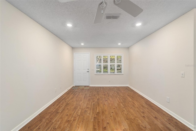 unfurnished room featuring a textured ceiling, hardwood / wood-style flooring, and ceiling fan