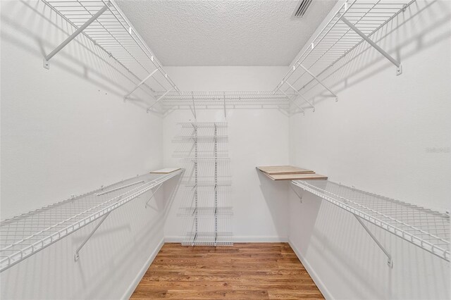 walk in closet with hardwood / wood-style floors