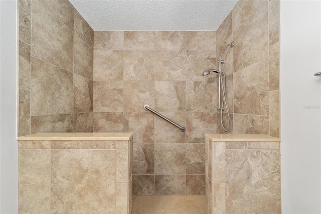 interior details featuring a textured ceiling and tiled shower