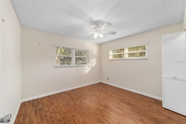 empty room featuring a textured ceiling, hardwood / wood-style flooring, and ceiling fan