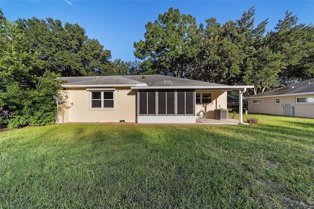 back of house with central air condition unit, a patio area, a lawn, and a sunroom