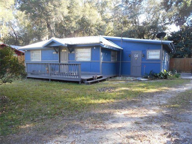 view of front facade with a wooden deck and a front lawn