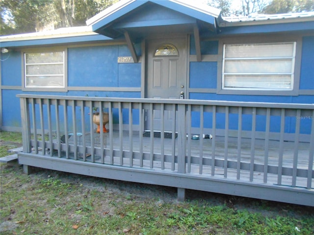 view of exterior entry featuring a deck