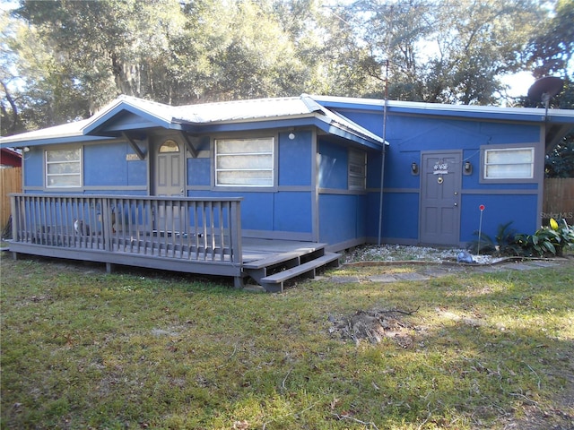 view of front of home featuring a front yard and a wooden deck