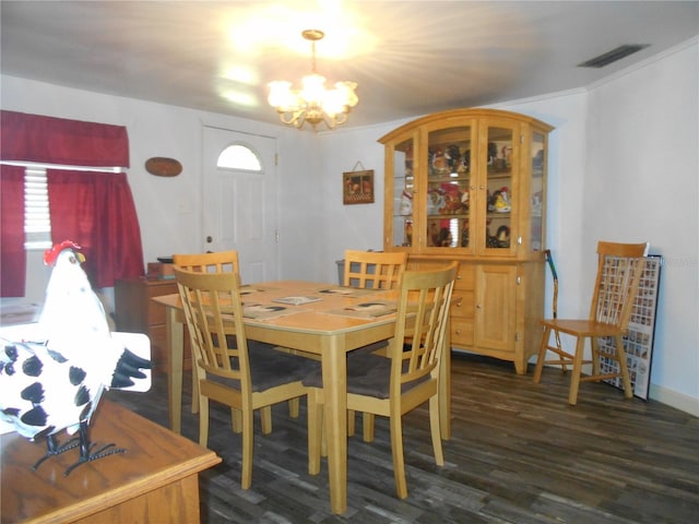 dining area with ornamental molding, a chandelier, and dark hardwood / wood-style floors