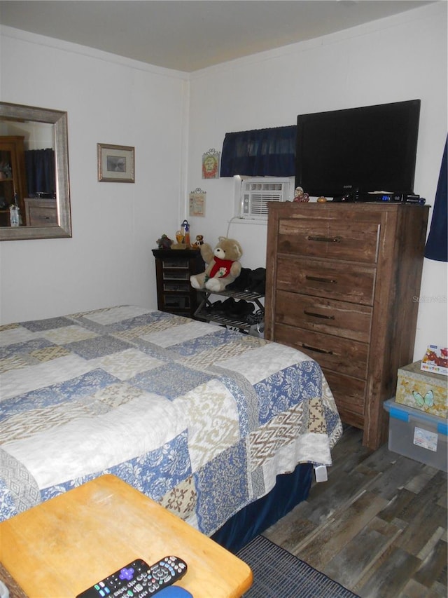 bedroom with crown molding and dark hardwood / wood-style flooring