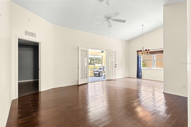 unfurnished room featuring a textured ceiling, high vaulted ceiling, dark hardwood / wood-style floors, ceiling fan with notable chandelier, and french doors