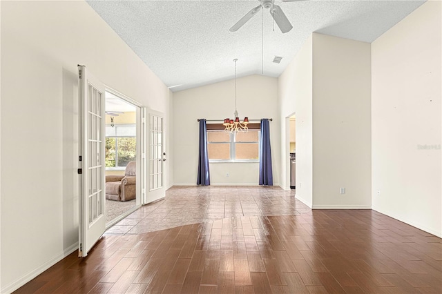 spare room with french doors, a textured ceiling, ceiling fan with notable chandelier, and hardwood / wood-style floors