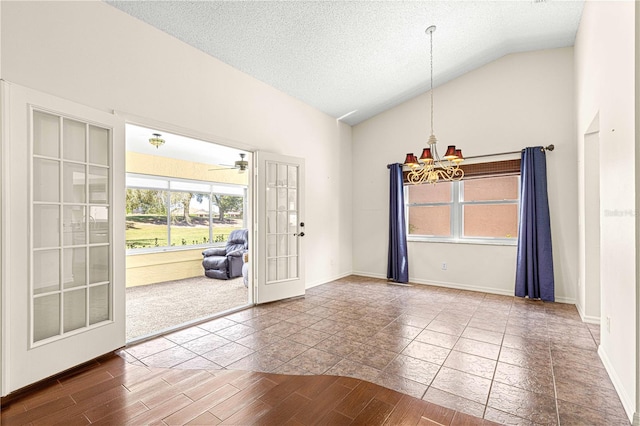 interior space with tile patterned floors, french doors, ceiling fan with notable chandelier, a textured ceiling, and high vaulted ceiling