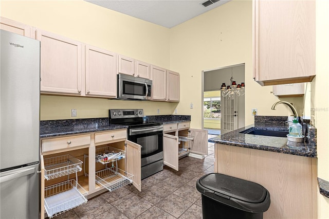 kitchen featuring sink, light tile patterned flooring, stainless steel appliances, dark stone counters, and light brown cabinets