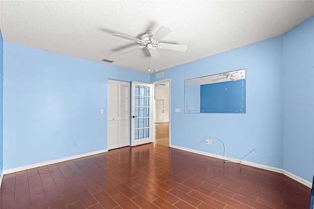 unfurnished room featuring ceiling fan, a textured ceiling, and dark hardwood / wood-style floors