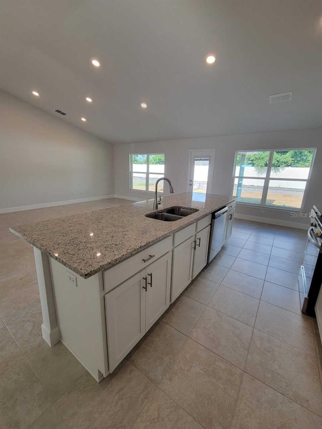 kitchen with light stone countertops, sink, an island with sink, stainless steel dishwasher, and white cabinets