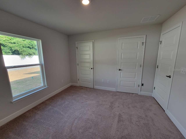 unfurnished bedroom featuring light colored carpet