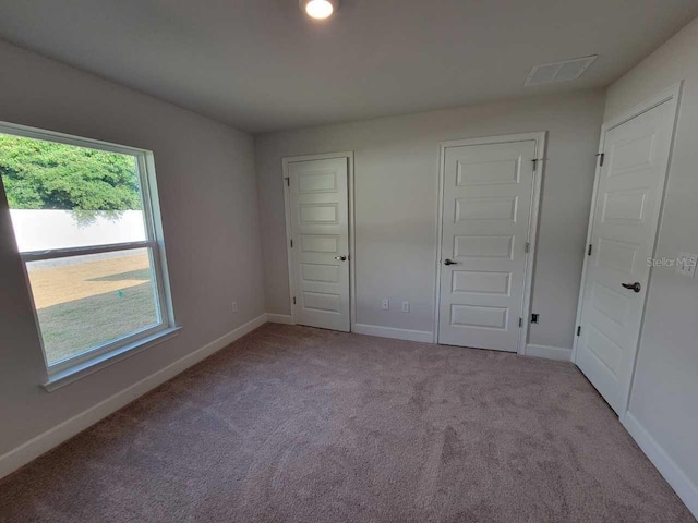 unfurnished bedroom featuring light carpet