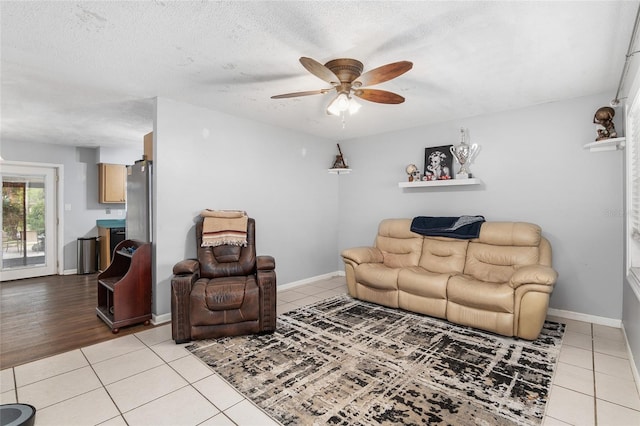 living room featuring a textured ceiling, light hardwood / wood-style floors, and ceiling fan