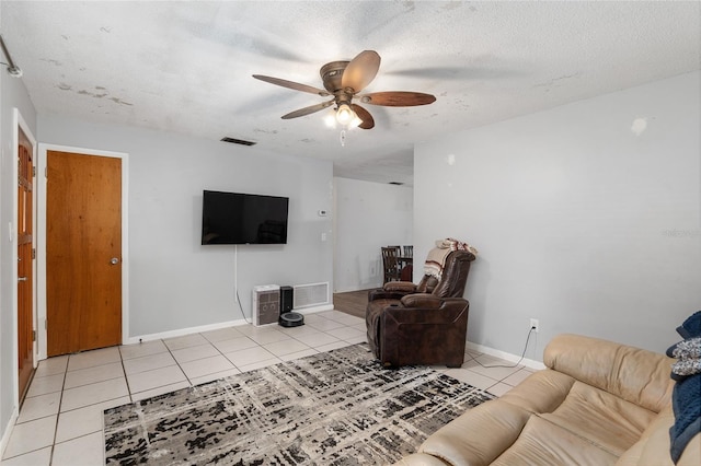 tiled living room featuring ceiling fan and a textured ceiling