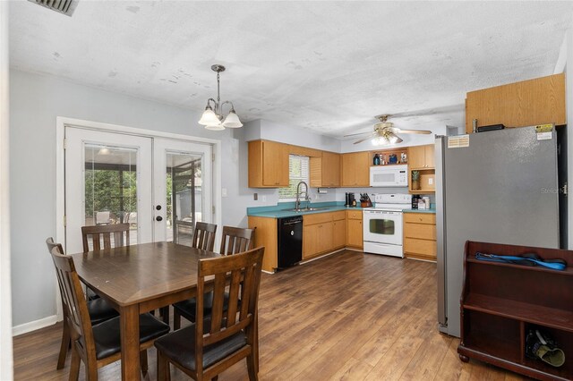 kitchen with a wealth of natural light, sink, pendant lighting, and white appliances