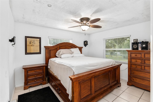 tiled bedroom featuring ceiling fan and a textured ceiling