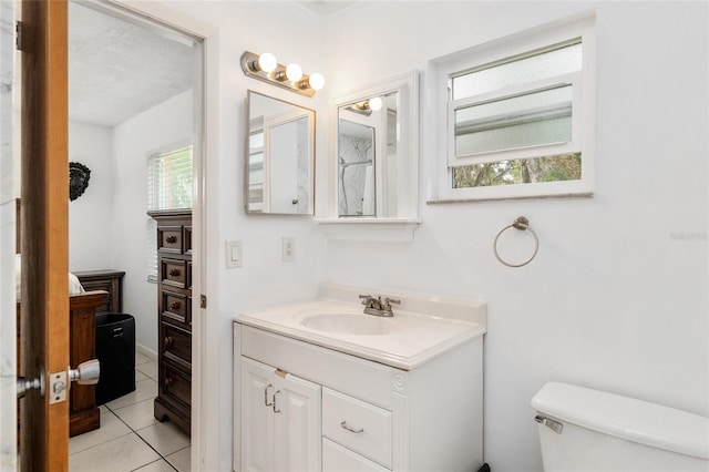 bathroom featuring vanity, a textured ceiling, toilet, and tile patterned flooring