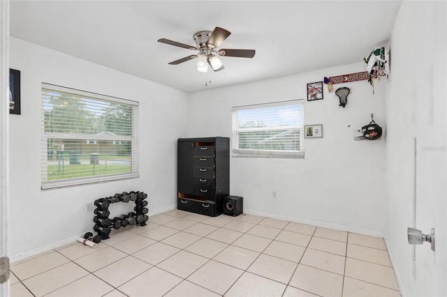 tiled spare room with ceiling fan