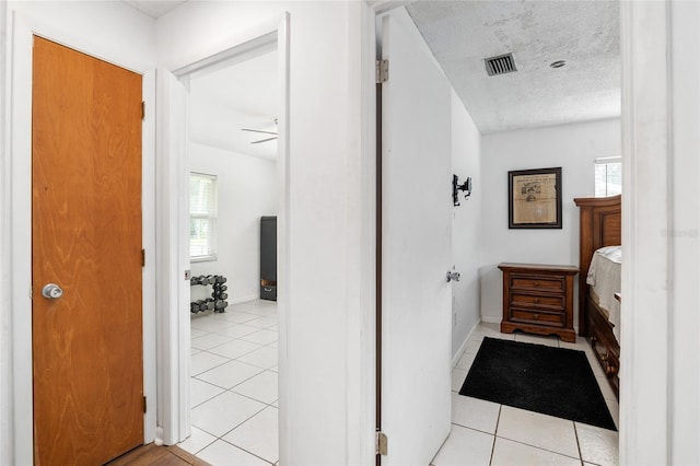 bathroom featuring a textured ceiling, ceiling fan, and tile patterned flooring