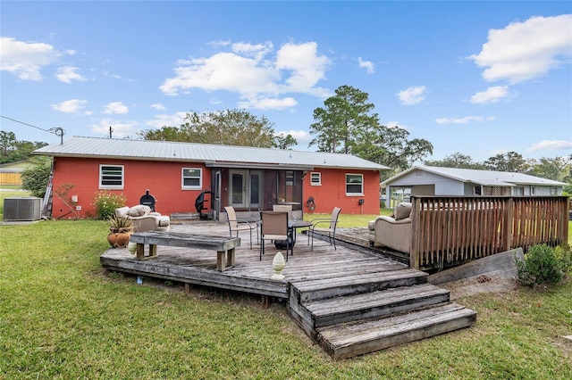 rear view of house featuring central AC, a wooden deck, and a yard