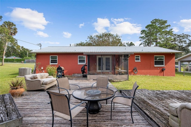 rear view of house featuring a wooden deck, a lawn, and central air condition unit