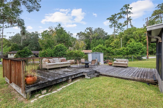 wooden deck with an outdoor living space, a storage unit, and a yard