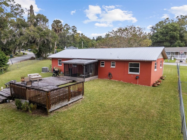 back of property with a yard, a sunroom, central AC, and a deck