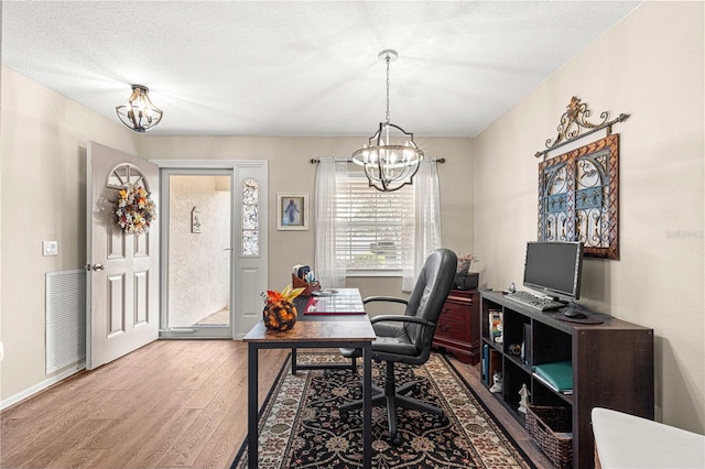 home office featuring a chandelier, hardwood / wood-style floors, and a textured ceiling