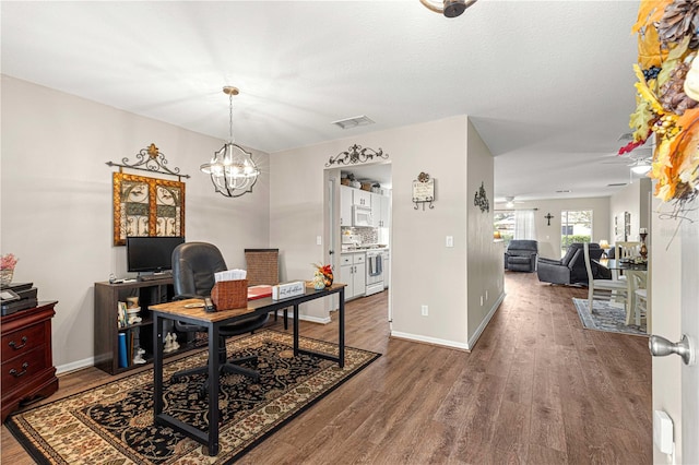 office area featuring an inviting chandelier and hardwood / wood-style flooring