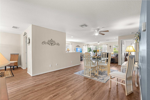 dining space featuring ceiling fan, hardwood / wood-style floors, and a textured ceiling