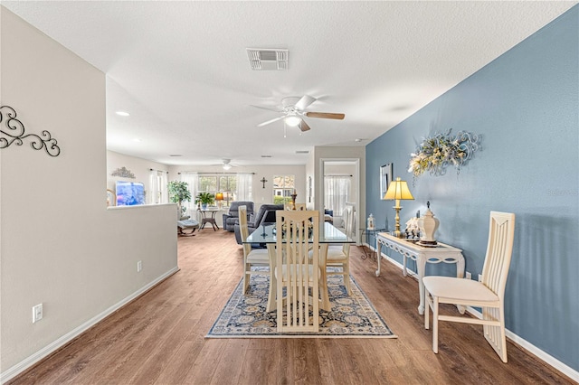 dining space featuring a textured ceiling, hardwood / wood-style flooring, and ceiling fan